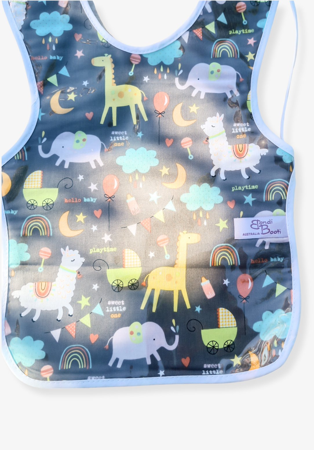 Laminated toddler feeding bib with a whimsical nighttime animal design, featuring giraffes, elephants, rainbows, and clouds on a dark grey background, with white trim and tie closure, laid flat on a grey background.