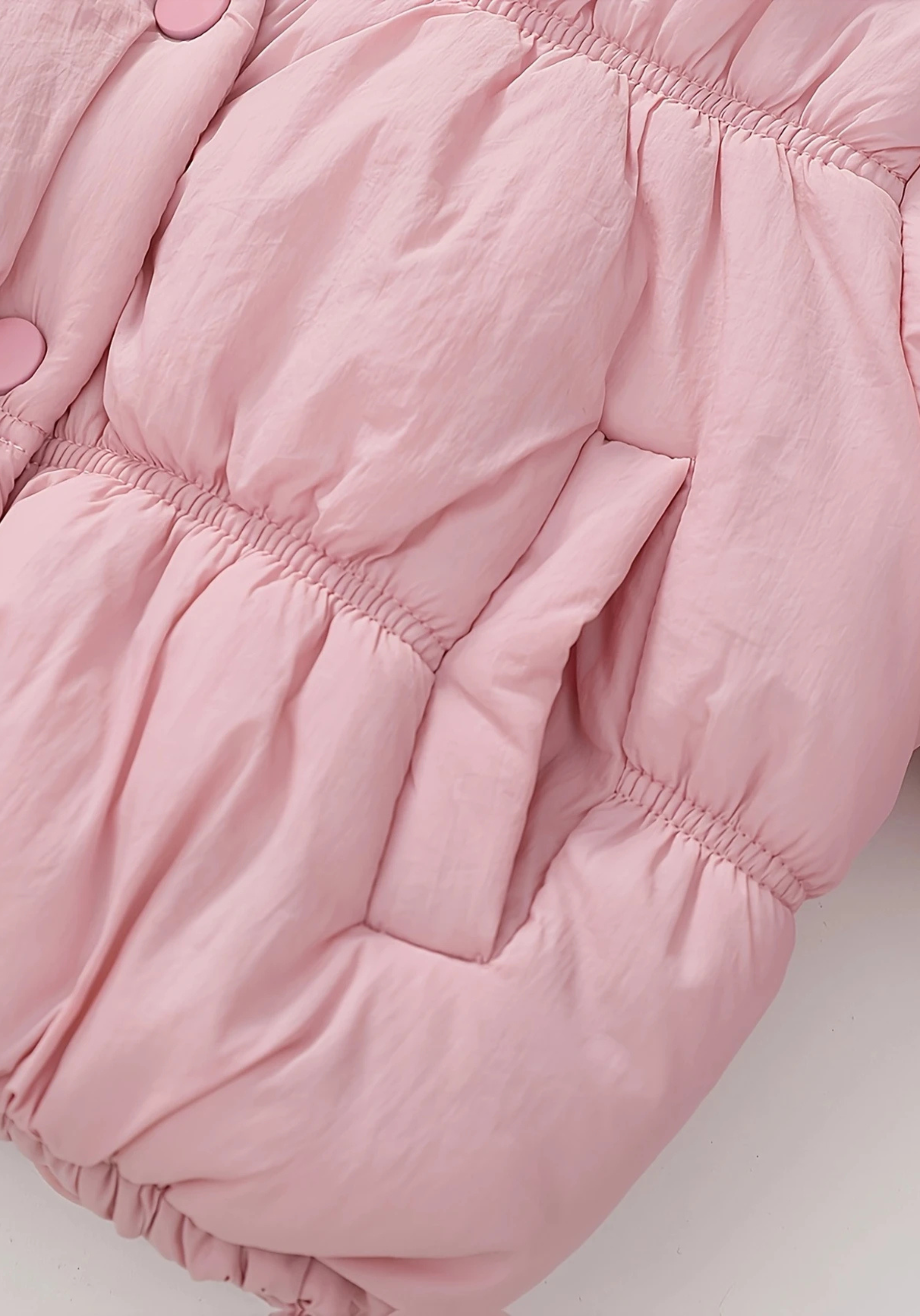 Close up view of toddler pink puffer jacket with ruched detailing and high collar