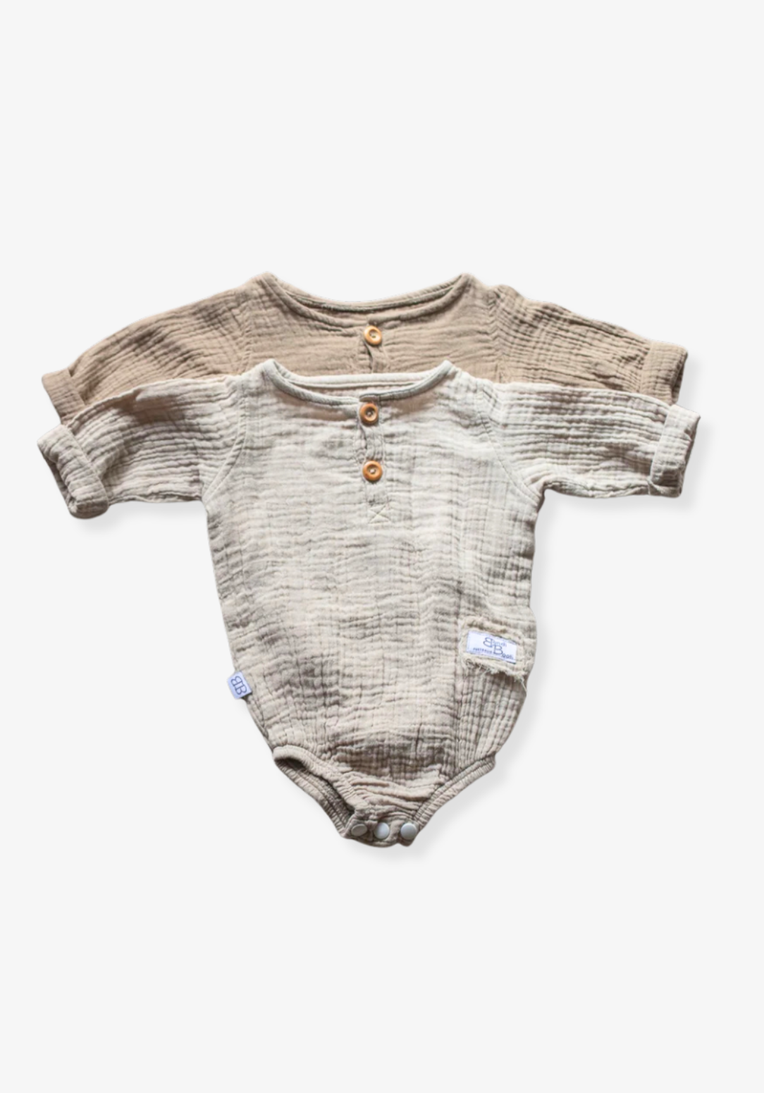 Organic cotton baby romper in beige with long sleeves and button-down front, displayed on a grey background