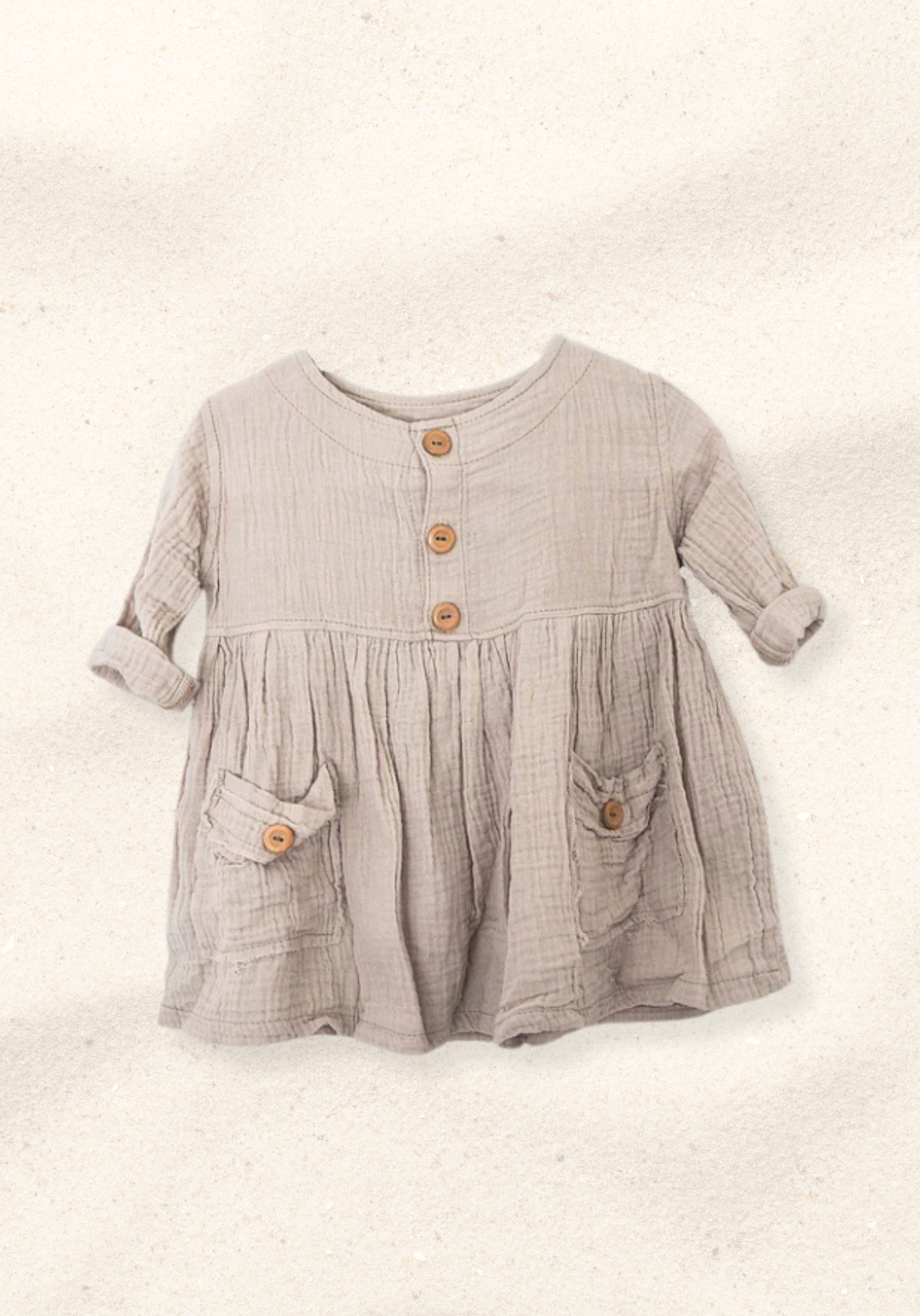 Beige organic cotton sun dress for baby girls with wooden front buttons, rolled sleeves, and front pockets