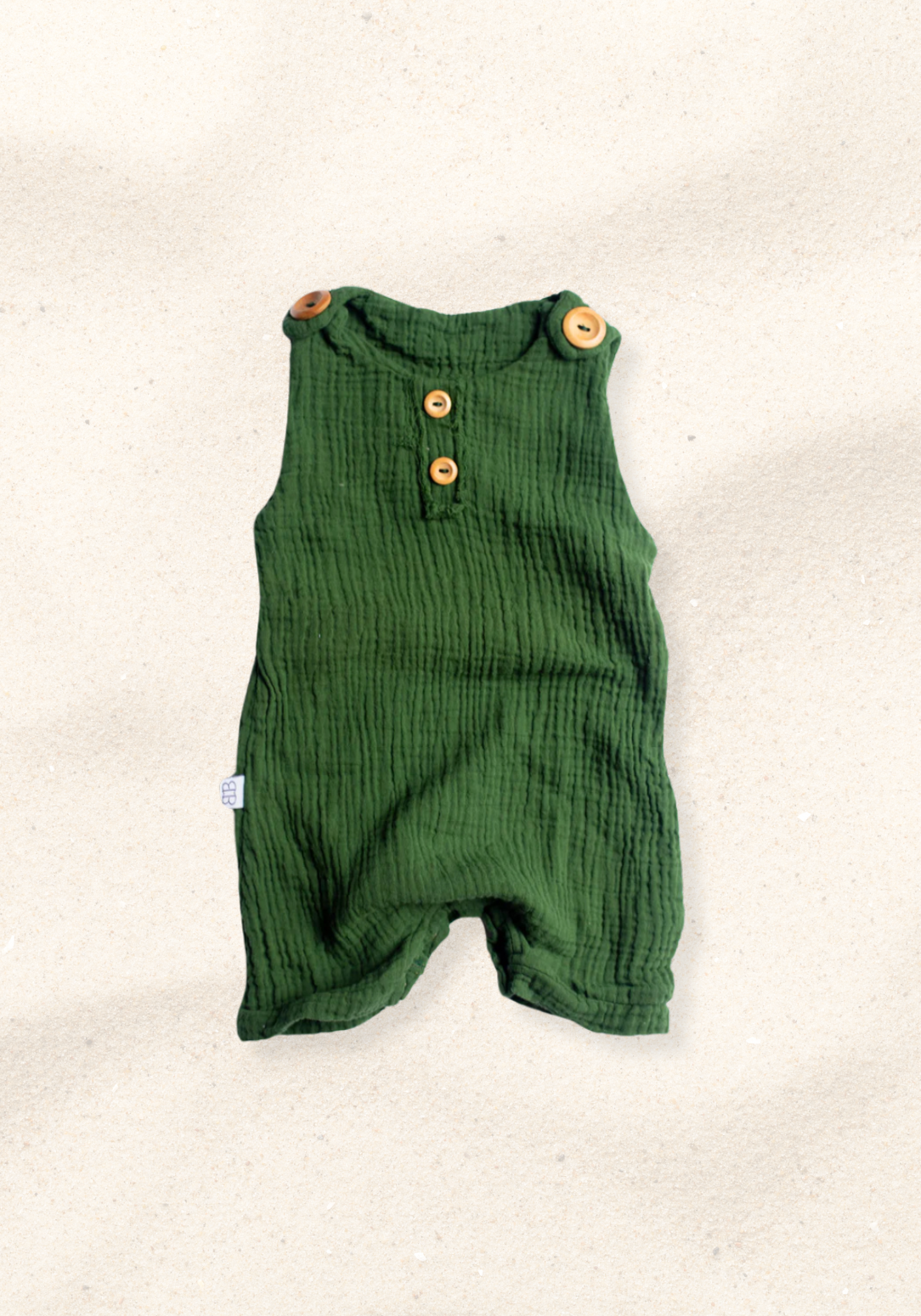 Baby romper in deep green organic cotton with overall-style wooden button straps