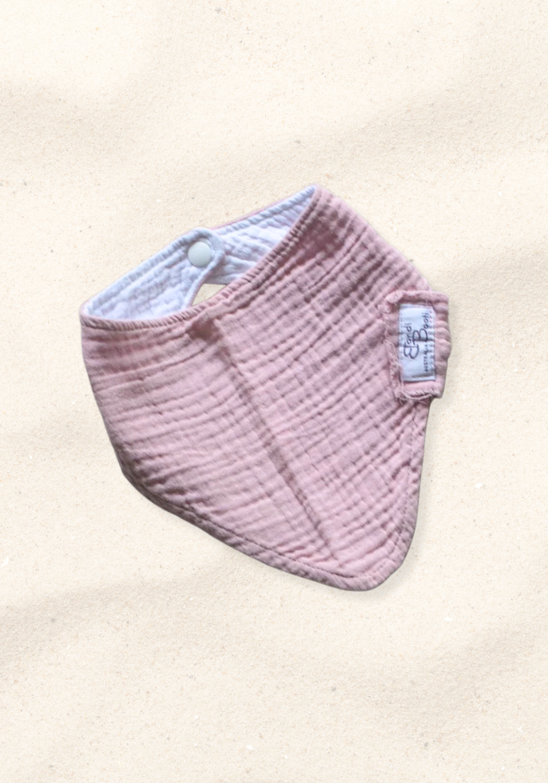 Bandana-style baby dribble bib in dusty pink made from organic cotton with absorbent lining.
