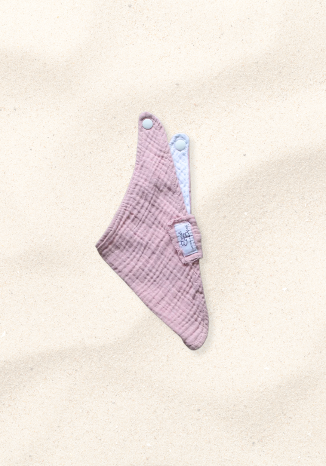 Bandana-style baby dribble bib in dusty pink made from organic cotton with absorbent lining.