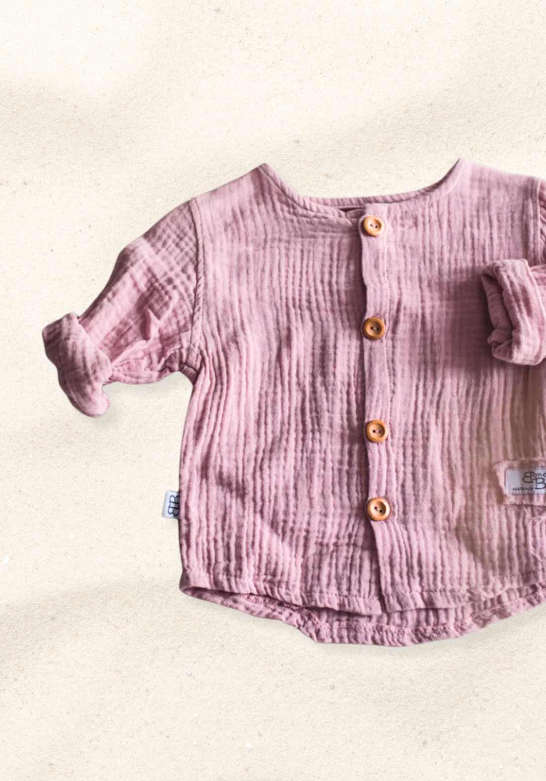 Dusty pink baby and toddler island-style shirt made from organic cotton with short sleeves and wooden buttons