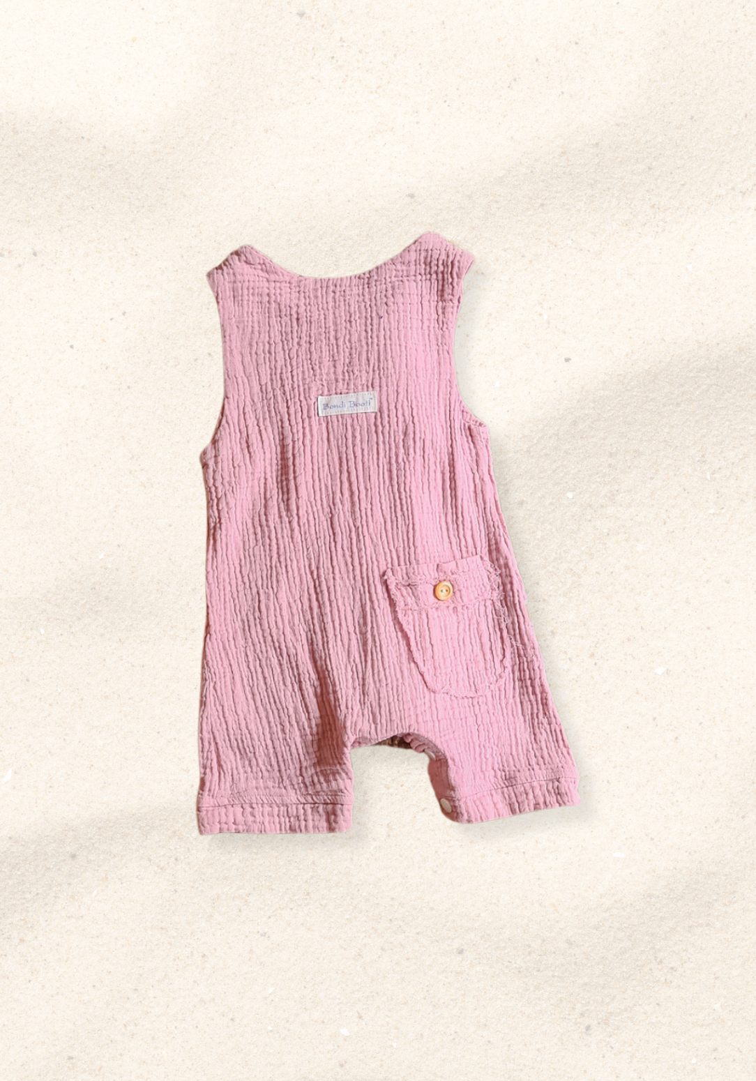 Dusty pink organic cotton baby overall onesie with wooden button shoulder straps and soft elastic leg openings