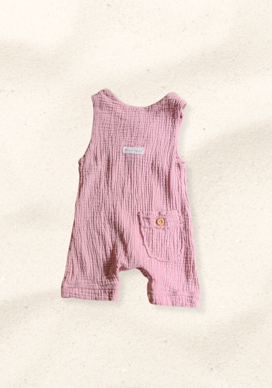 Dusty pink organic cotton baby overall onesie with wooden button shoulder straps and soft elastic leg openings