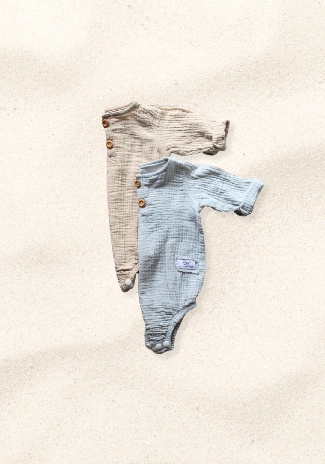 French grey long sleeve baby romper made from soft organic cotton with wooden button front and snap closures.
