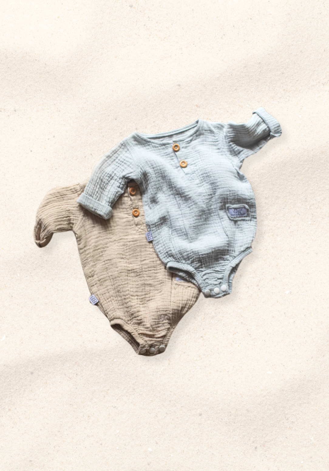 French grey long sleeve baby romper made from soft organic cotton with wooden button front and snap closures.