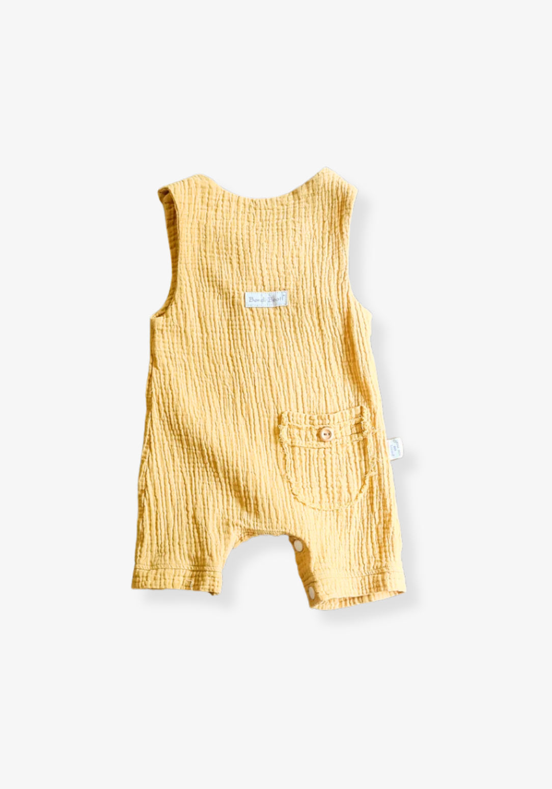 Mustard-colored organic cotton baby overall onesie with easy-change snaps on the bottom and wooden buttons on the shoulders.