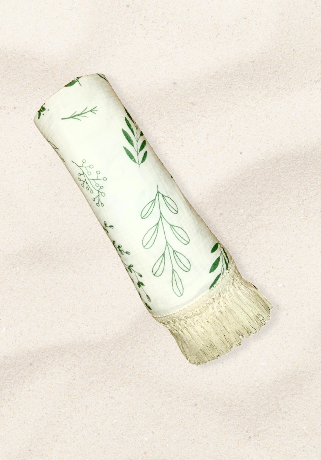 White cotton baby blanket with green botanical leaf print and boho-inspired fringe border. Naturally breathable.