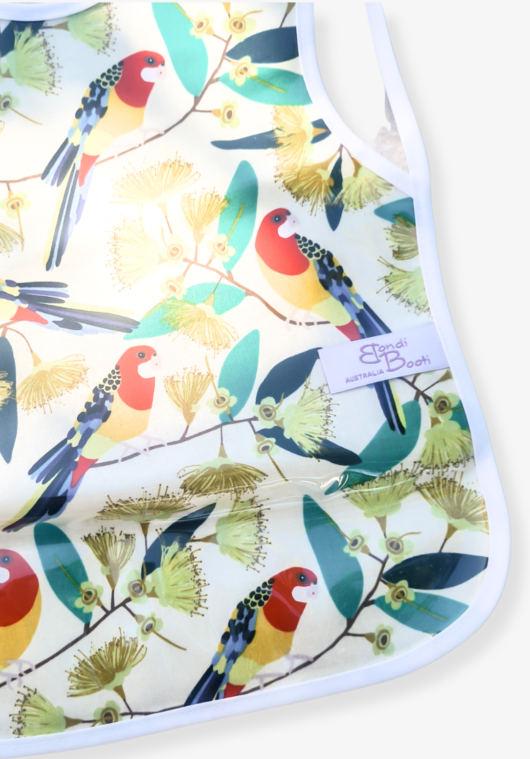 Laminated toddler feeding bib with a vibrant print of red and yellow native Australian birds perched on eucalyptus branches, white trim edges, and tie closure, displayed flat on a grey background.