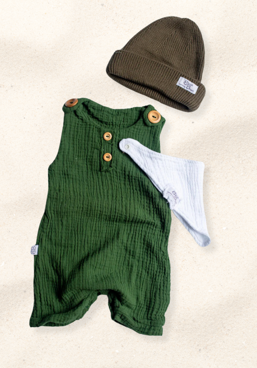 Baby romper in deep green organic cotton with overall-style wooden button straps