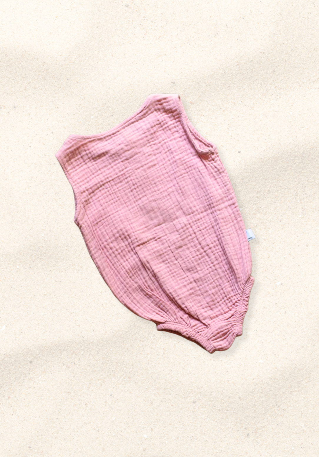Organic cotton baby romper in dusty pink with snap buttons at the bottom and elasticised leg bands.