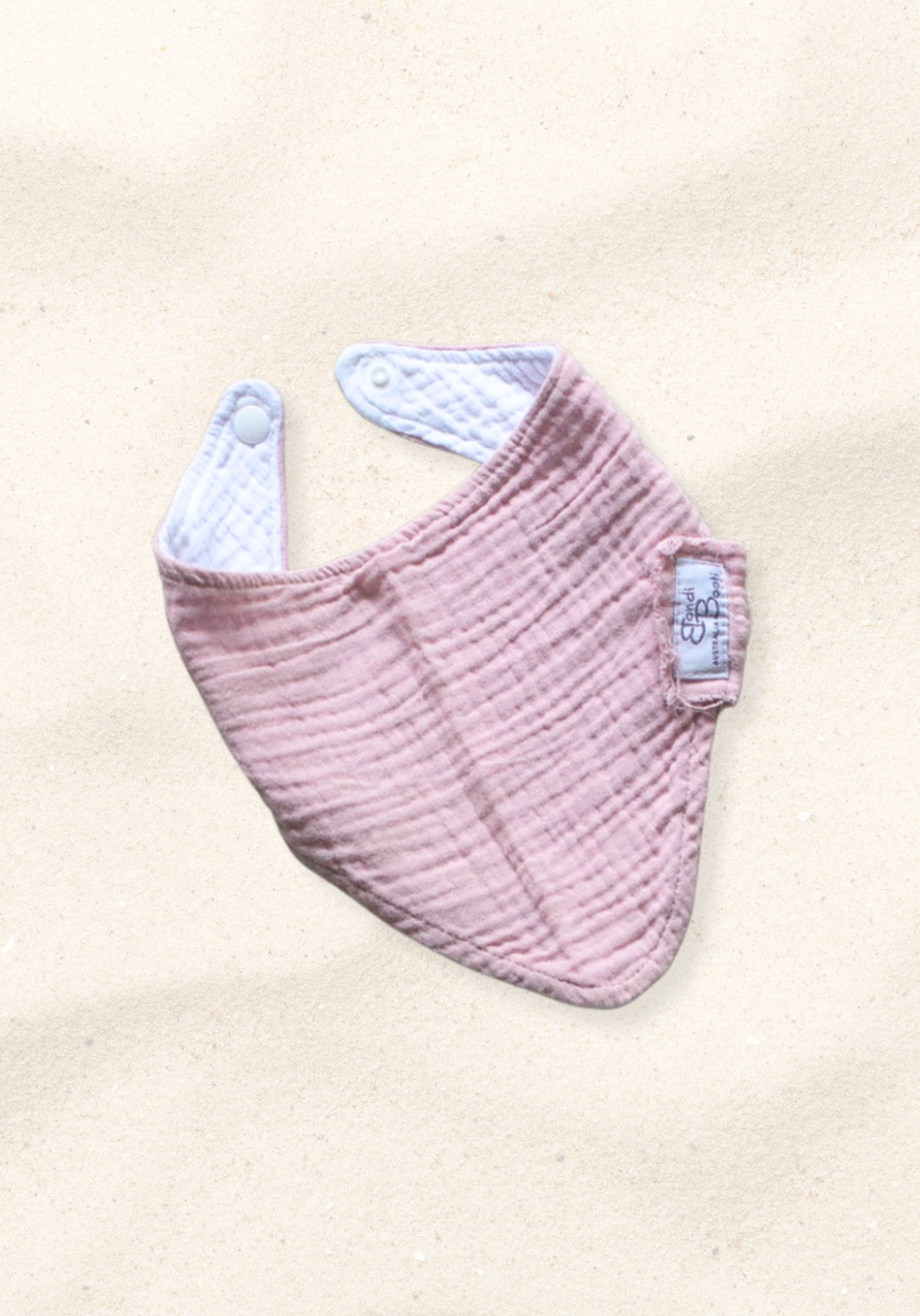 Bandana-style baby dribble bib in dusty pink made from organic cotton with absorbent lining.
