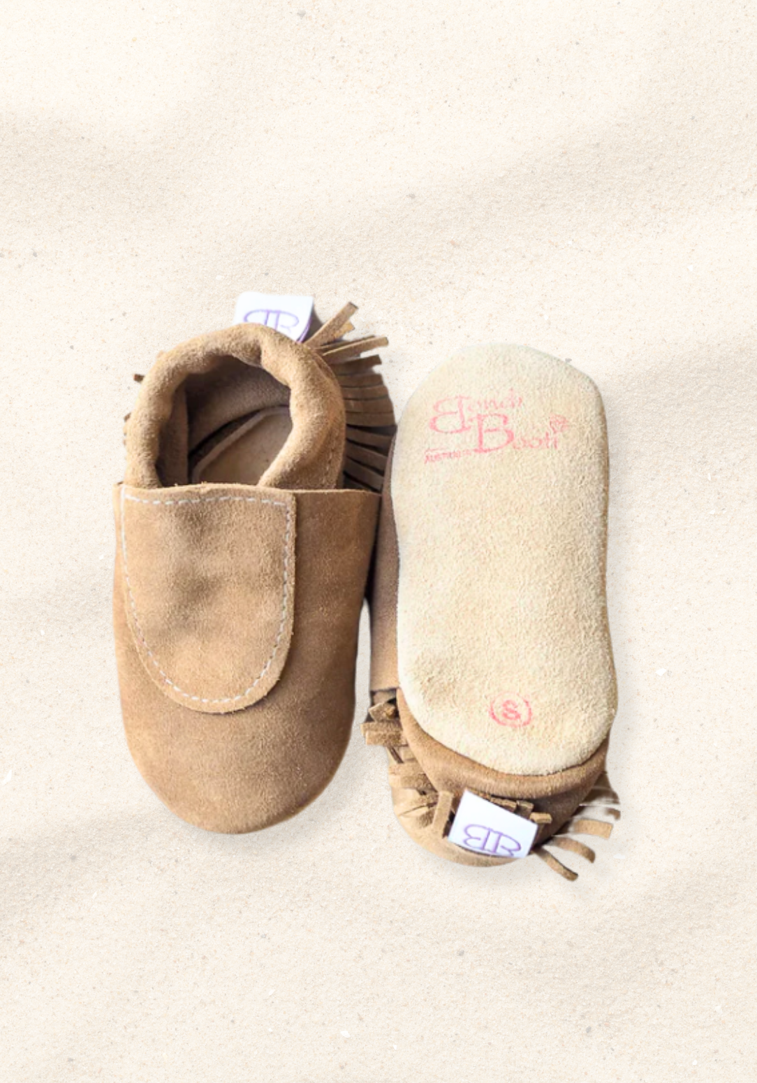 Soft sole baby moccasins in natural leather with fringe trim and suede finish