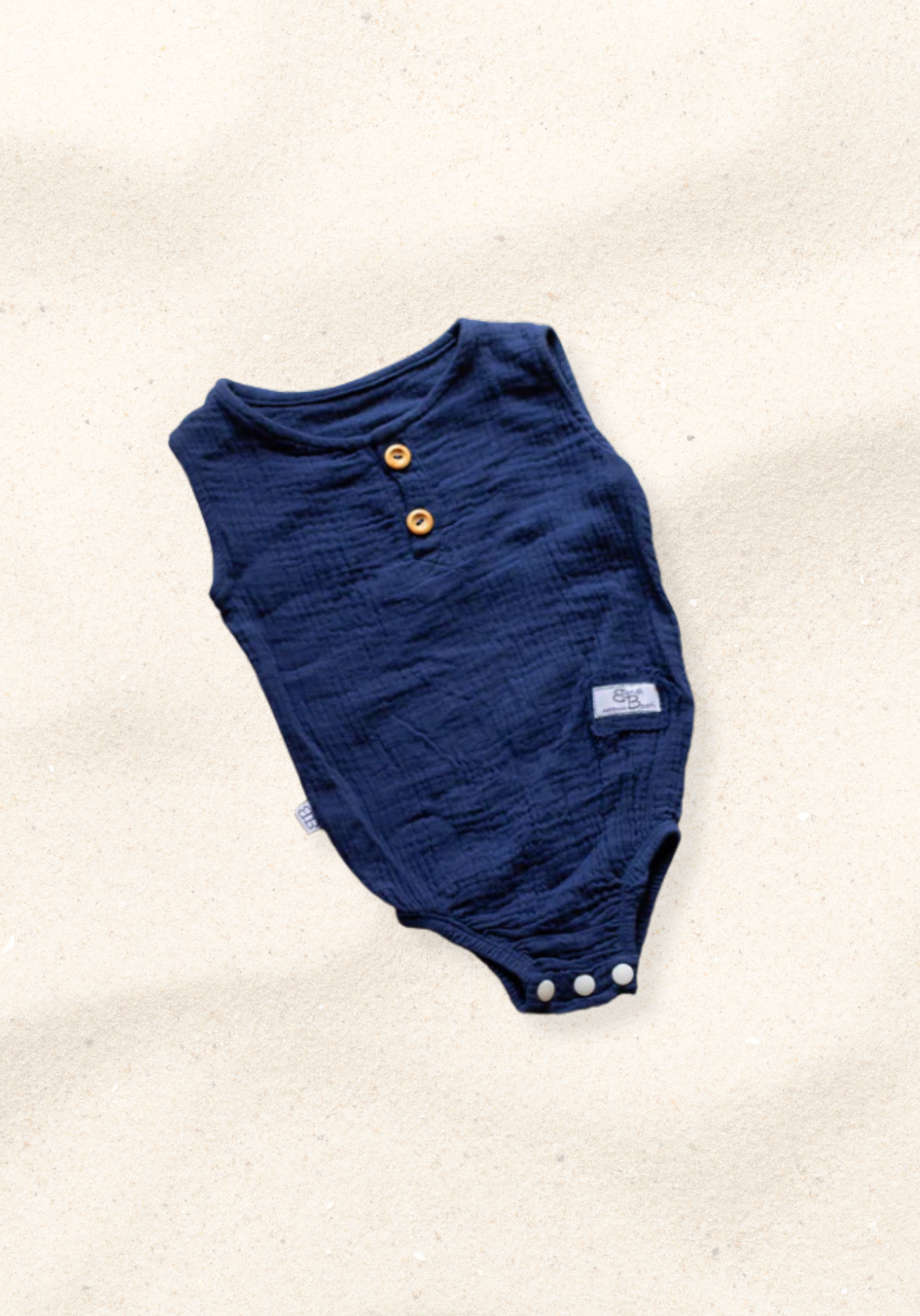 Navy short sleeve baby romper made from organic cotton with three snap buttons at the bottom and elasticised leg bands