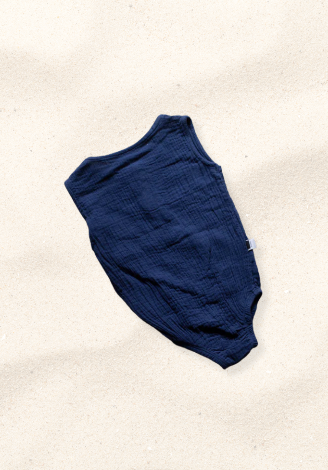 Navy short sleeve baby romper made from organic cotton with three snap buttons at the bottom and elasticised leg bands