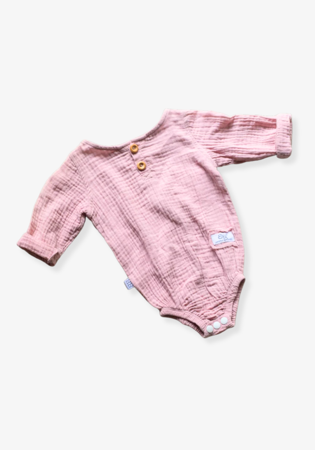 Front view of pink muslin long sleeve baby romper with buttons and snap closure on grey background